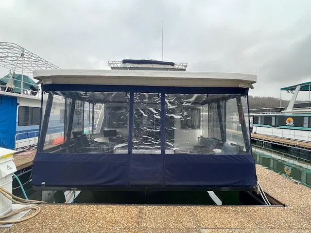 Slide: The Image of Houseboat with blue canopy docked at marina, Funtime 16x72 model, year 2000. - 2