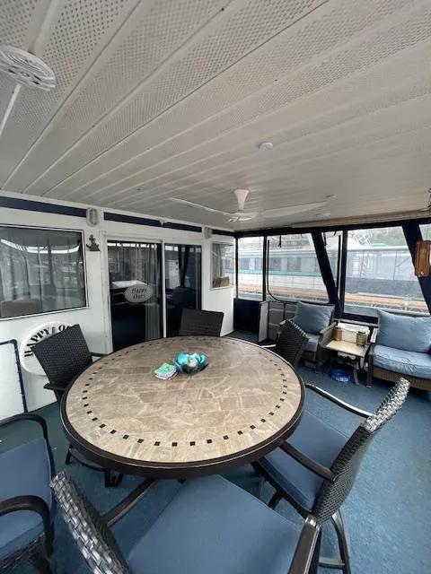 Slide: The Image of Spacious interior of 2000 Funtime 16x72 houseboat with round table and seating. - 3
