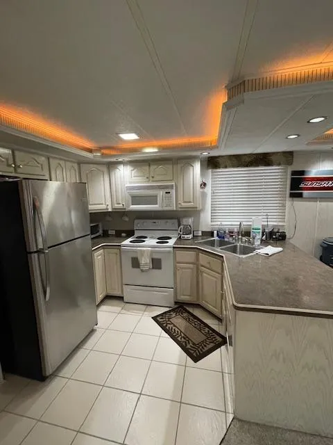 Slide: The Image of Modern kitchen in a 2000 Funtime 16x72 houseboat with stainless steel appliances and ambient lighting. - 5