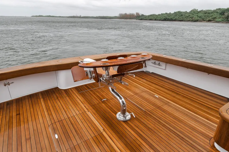 Slide: The Image of 2011 Jim Smith Custom Sportfish boat with teak deck and fishing chair, overlooking calm waters. - 10