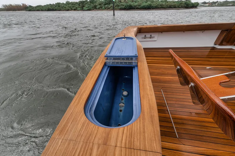 Slide: The Image of 2011 Jim Smith Custom Sportfish boat with wooden deck and blue storage compartment. - 12