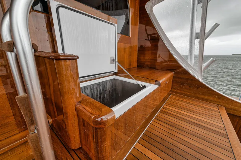 Slide: The Image of Luxurious 2011 Jim Smith Custom Sportfish boat with elegant wooden deck and open storage compartment. - 17