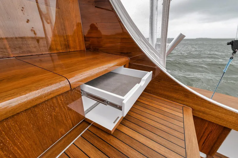 Slide: The Image of Wooden interior of 2011 Jim Smith Custom Sportfish boat with open drawer, overlooking the sea. - 19