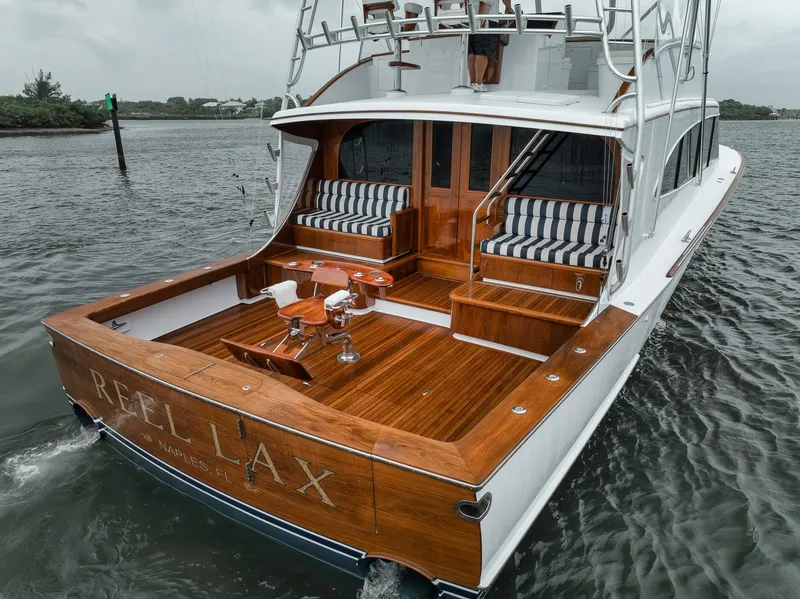 Slide: The Image of 2011 Jim Smith Custom Sportfish boat with wooden deck and striped seating on the water. - 6