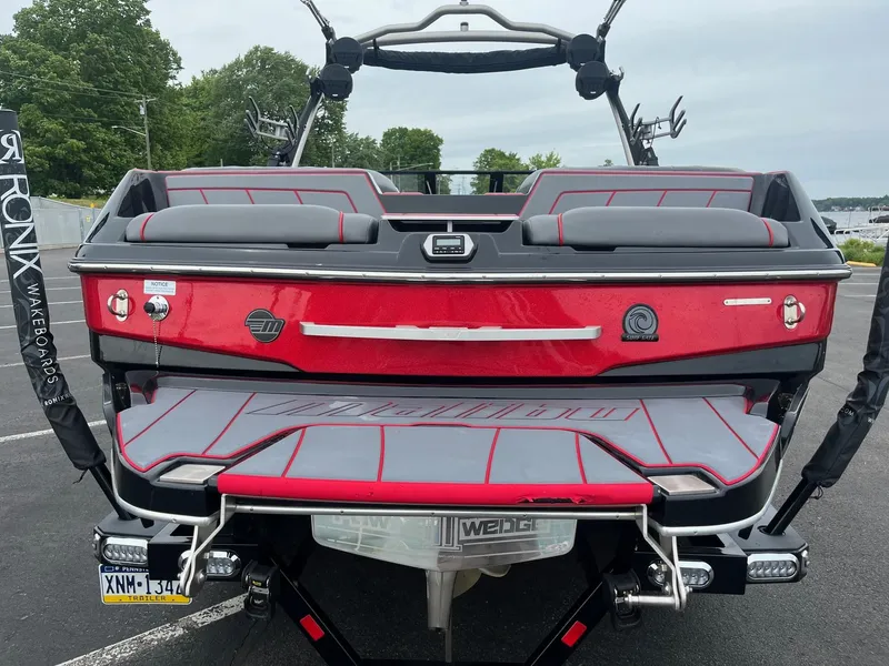 Slide: The Image of 2022 Malibu Wakesetter 23 LSV boat, red and gray, rear view, parked outdoors. - 8