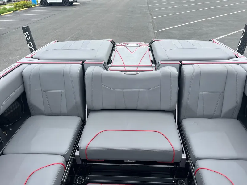 Slide: The Image of 2022 Malibu Wakesetter 23 LSV interior with gray and red-trimmed seating in a parking lot. - 9