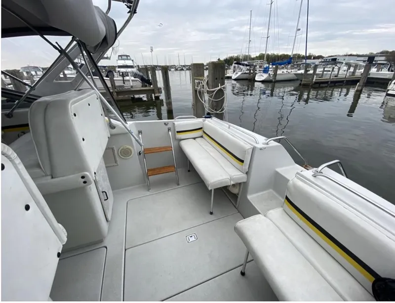 Slide: The Image of 1987 Chris-Craft 320 Amerosport boat interior at marina, featuring white seating and calm waters. - 13