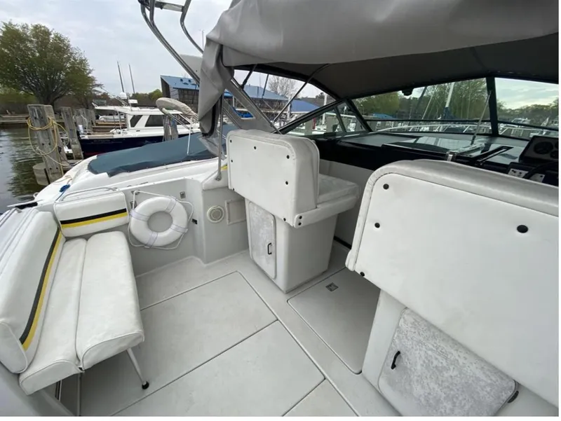 Slide: The Image of 1987 Chris-Craft 320 Amerosport boat interior with white seating and helm, docked at marina. - 14