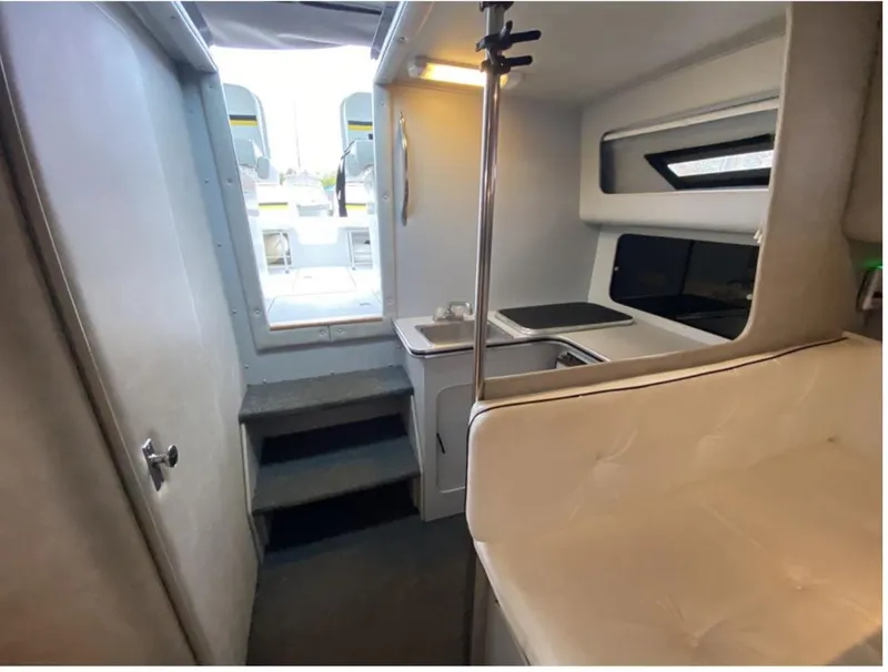 Slide: The Image of Interior of 1987 Chris-Craft 320 Amerosport boat, featuring compact kitchen and seating area. - 21
