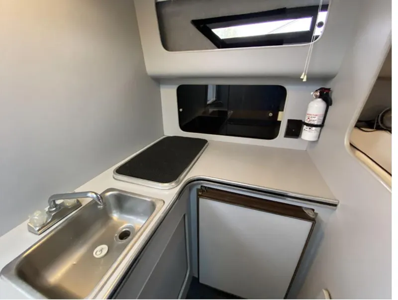 Slide: The Image of 1987 Chris-Craft 320 Amerosport boat kitchen with sink, stove, and compact fridge. - 22