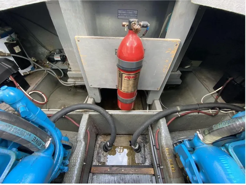 Slide: The Image of Engine compartment of 1987 Chris-Craft 320 Amerosport with fire extinguisher and blue engine components. - 28