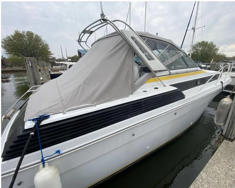 Slide: The Image of 1987 Chris-Craft 320 Amerosport boat docked in a marina, covered with a gray tarp. - 5