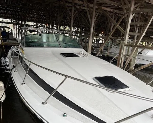 Slide: The Image of 1987 Chris-Craft 320 Amerosport boat docked under wooden shelter. - 6