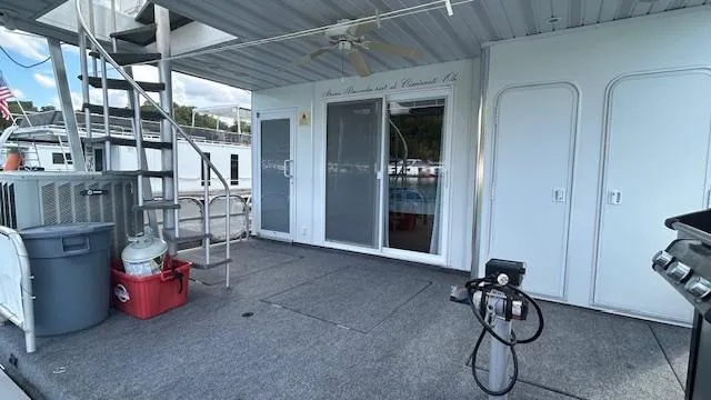 Slide: The Image of 2007 Sharpe 18 x 85 Houseboat deck with stairs, sliding doors, and outdoor equipment. - 22