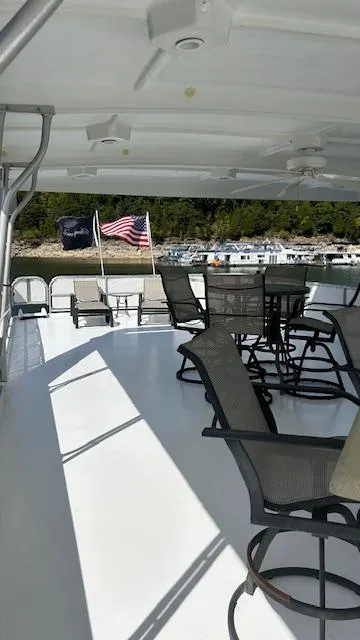 Slide: The Image of 2007 Sharpe 18 x 85 Houseboat deck with chairs, tables, and American flag. - 24