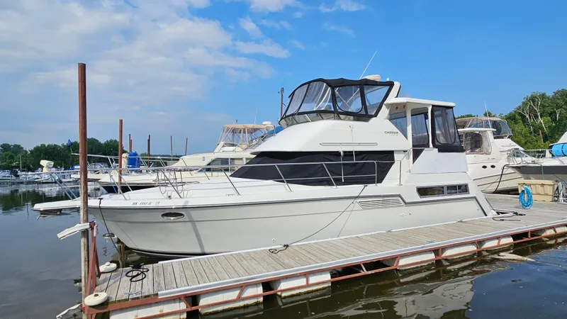 Slide: The Image of 1995 Carver 355 Aft Cabin yacht docked at a marina under a blue sky. - 2
