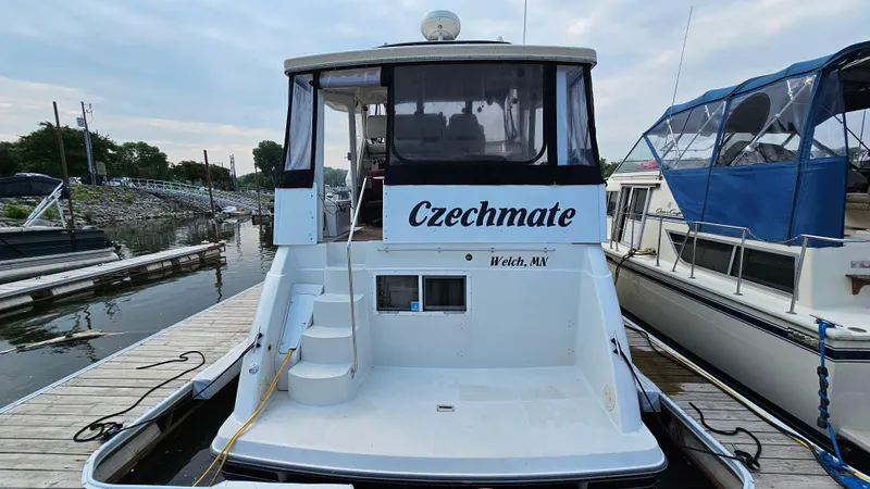 Slide: The Image of 1995 Carver 355 Aft Cabin yacht named "Czechmate" docked at a marina. - 4