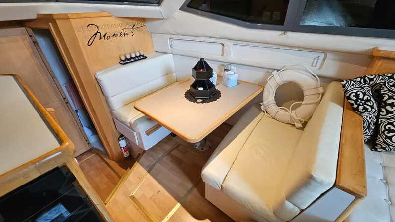 Slide: The Image of 1995 Carver 355 Aft Cabin interior with cozy seating and table setup. - 16