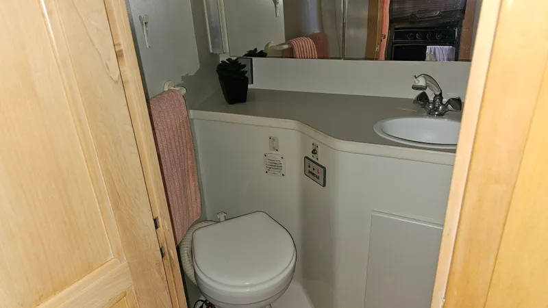 Slide: The Image of 1995 Carver 355 Aft Cabin bathroom with sink, toilet, and mirror. - 21