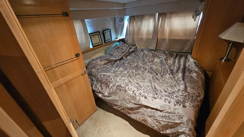 Slide: The Image of 1995 Carver 355 Aft Cabin bedroom with cozy bed and wooden cabinetry. - 23