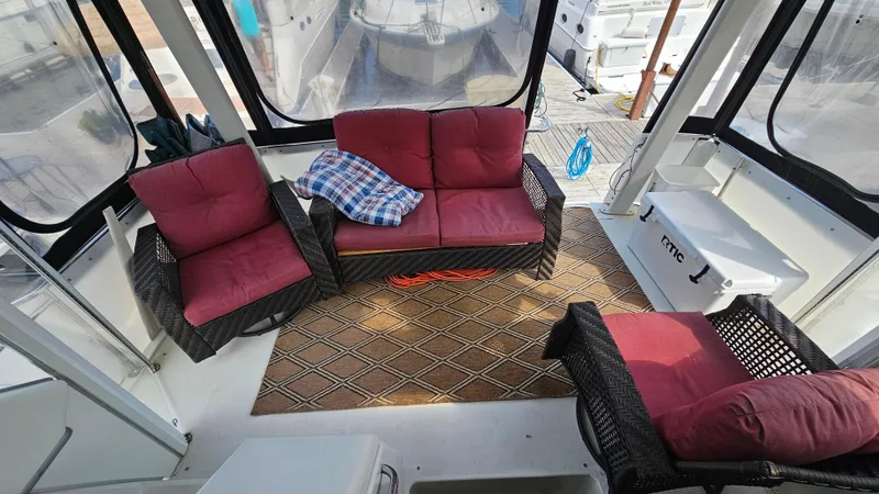 Slide: The Image of 1995 Carver 355 Aft Cabin interior with red cushioned seating and patterned rug. - 5