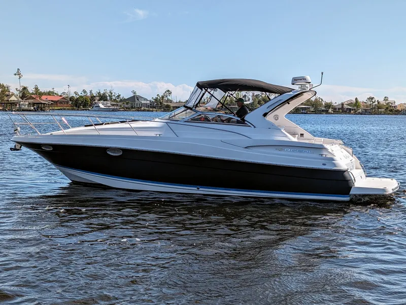 The Image of 2005 Regal 3560 yacht cruising on a calm lake with scenic background. - 1