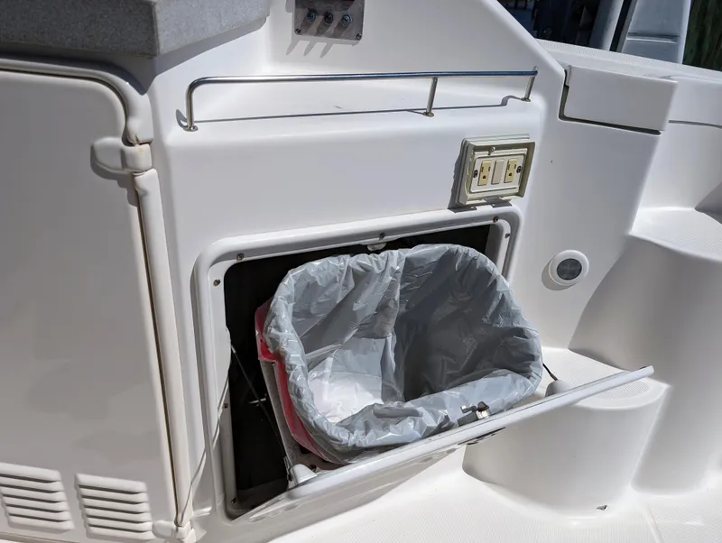 Slide: The Image of Built-in trash compartment on a 2005 Regal 3560 boat, featuring a plastic bag liner. - 11