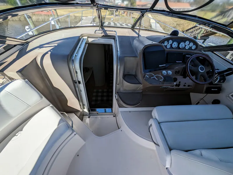Slide: The Image of 2005 Regal 3560 yacht cockpit with steering wheel, gauges, and cabin entrance. - 16