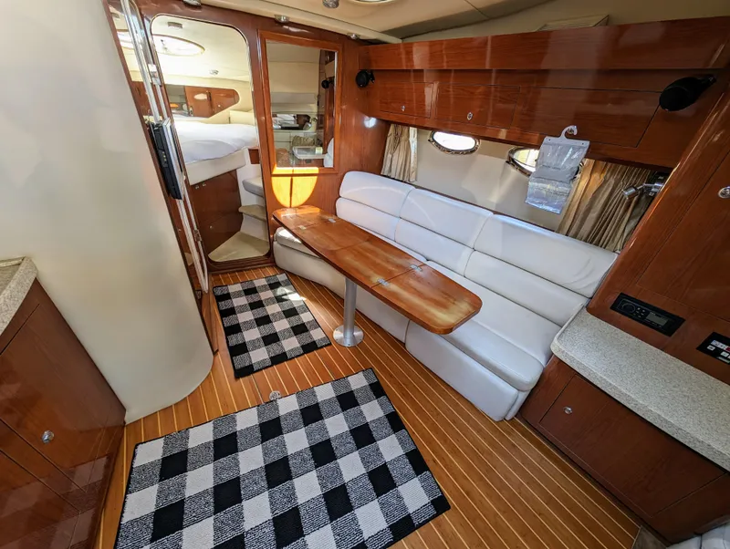 Slide: The Image of Interior of 2005 Regal 3560 yacht with wood accents, white seating, and checkered rugs. - 18