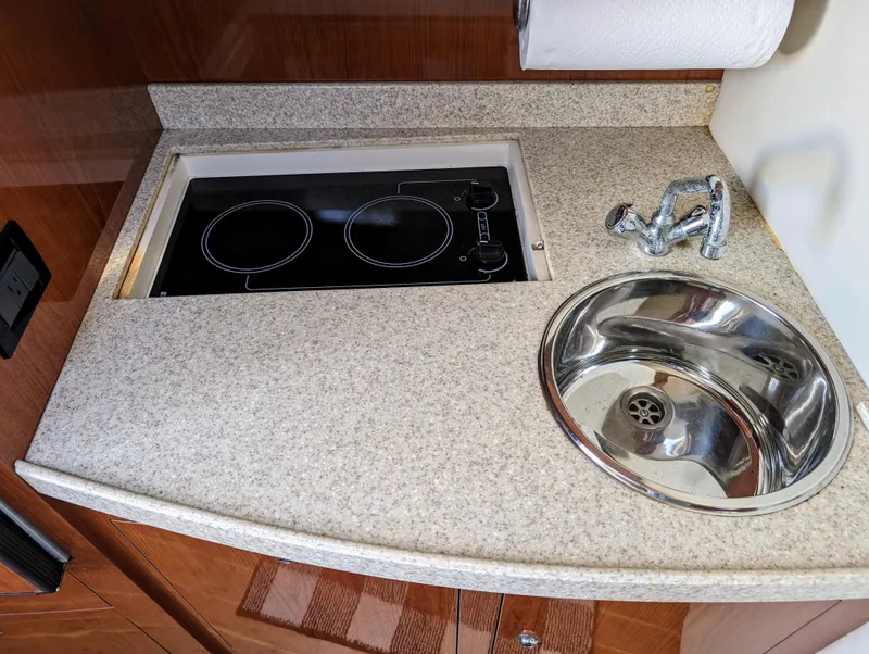 Slide: The Image of 2005 Regal 3560 yacht kitchen with stovetop and sink. - 21