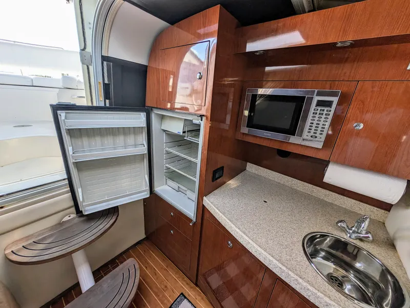 Slide: The Image of 2005 Regal 3560 yacht kitchen with open fridge, microwave, and sink. - 22