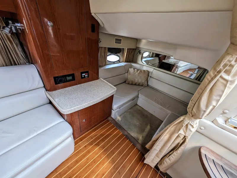 Slide: The Image of Interior of a 2005 Regal 3560 yacht with wood flooring and beige seating. - 23