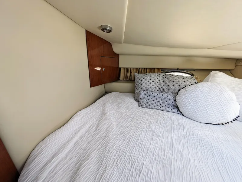 Slide: The Image of Cozy cabin interior of 2005 Regal 3560 yacht with plush bedding and wooden accents. - 28