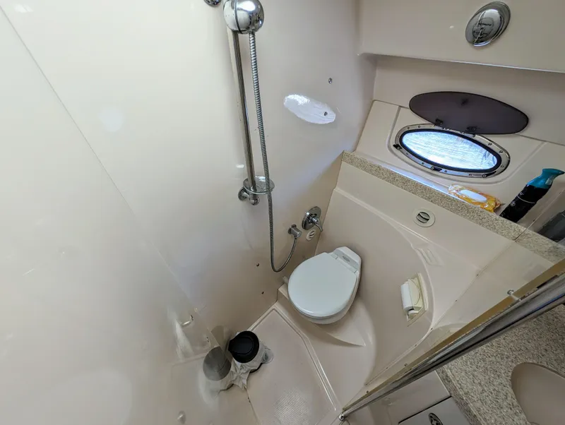 Slide: The Image of Compact bathroom in a 2005 Regal 3560 boat with shower and porthole window. - 32