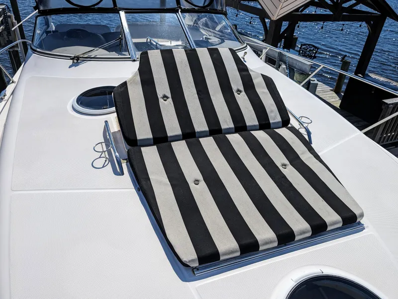 Slide: The Image of 2005 Regal 3560 yacht with striped sun loungers on deck, docked by the water. - 34