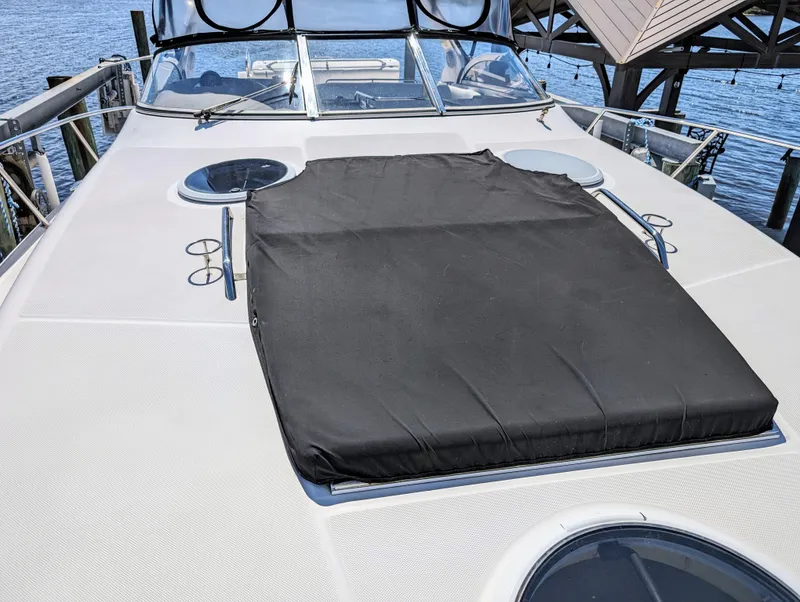 Slide: The Image of 2005 Regal 3560 yacht deck with black cover, docked by the water. - 35