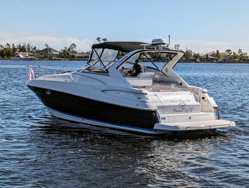 Slide: The Image of 2005 Regal 3560 yacht cruising on a serene lake with scenic background. - 40