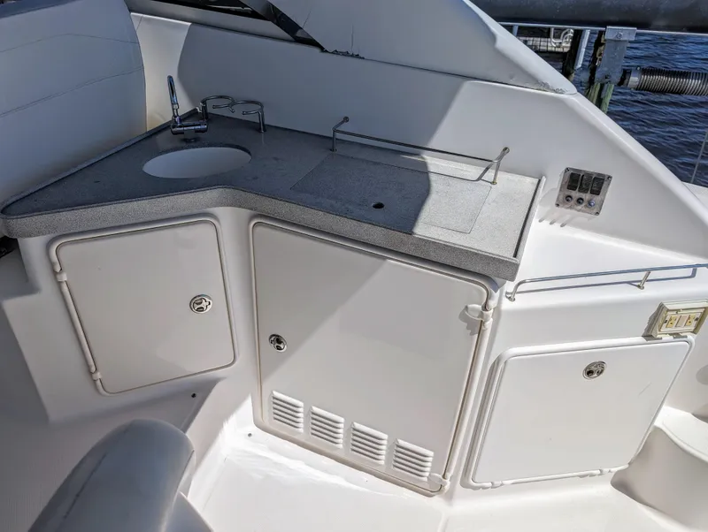 Slide: The Image of 2005 Regal 3560 yacht kitchenette with sink, storage cabinets, and control panel. - 9