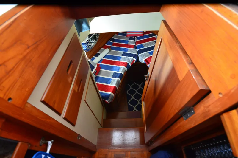 Slide: The Image of 1978 Grand Banks 36 Classic cabin interior with wooden finish and striped bedding. - 13