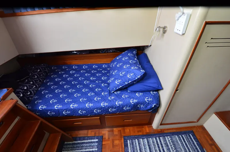 Slide: The Image of 1978 Grand Banks 36 Classic cabin with anchor-themed bedding and wooden interior. - 18