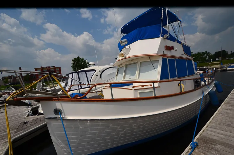 Slide: The Image of 1978 Grand Banks 36 Classic boat docked at marina under cloudy sky. - 2