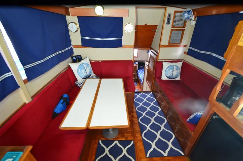 Slide: The Image of Interior of 1978 Grand Banks 36 Classic with red seating, blue curtains, and nautical decor. - 22