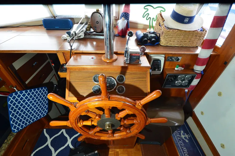 Slide: The Image of 1978 Grand Banks 36 Classic helm with wooden wheel, nautical decor, and navigation instruments. - 24