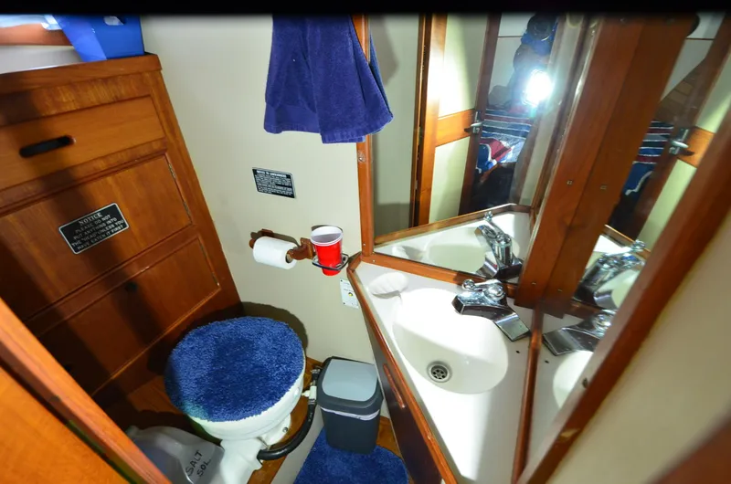Slide: The Image of 1978 Grand Banks 36 Classic bathroom with wooden cabinetry and blue accents. - 28