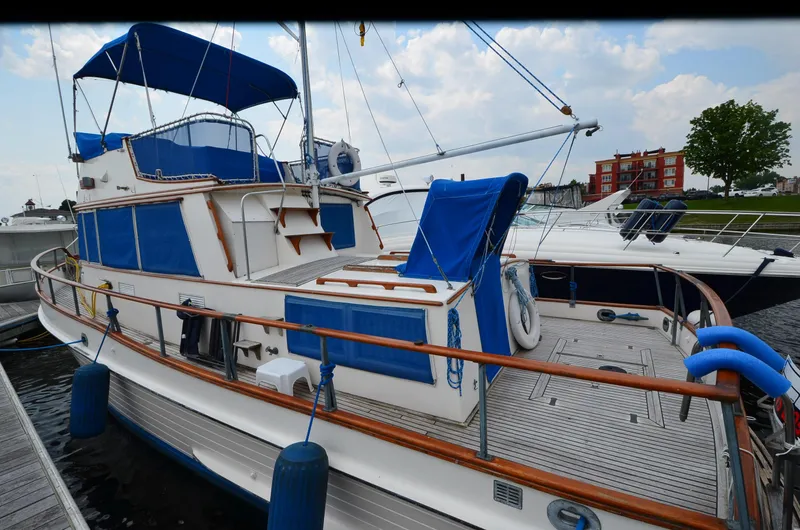 Slide: The Image of 1978 Grand Banks 36 Classic yacht docked, featuring blue canvas covers and wooden railings. - 3