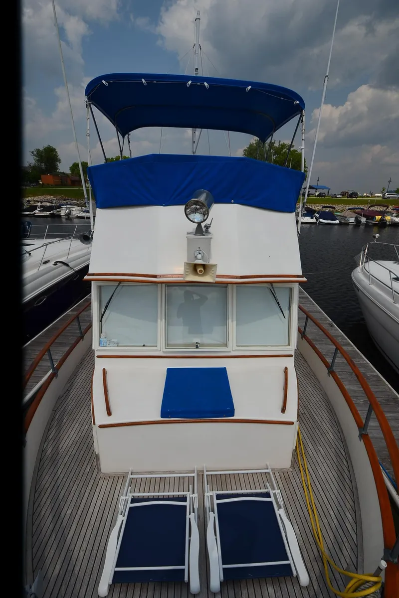 Slide: The Image of 1978 Grand Banks 36 Classic yacht with blue canopy and deck chairs. - 32