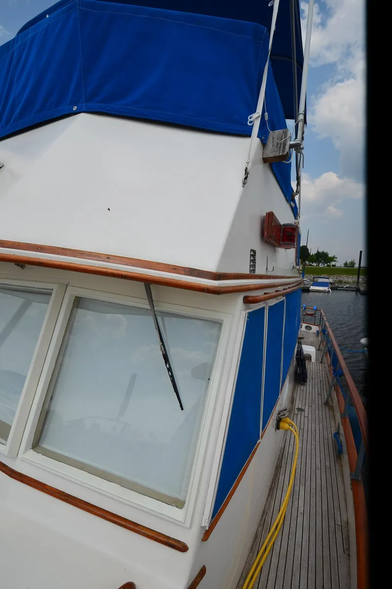 Slide: The Image of 1978 Grand Banks 36 Classic yacht with blue canopy and wooden deck. - 33