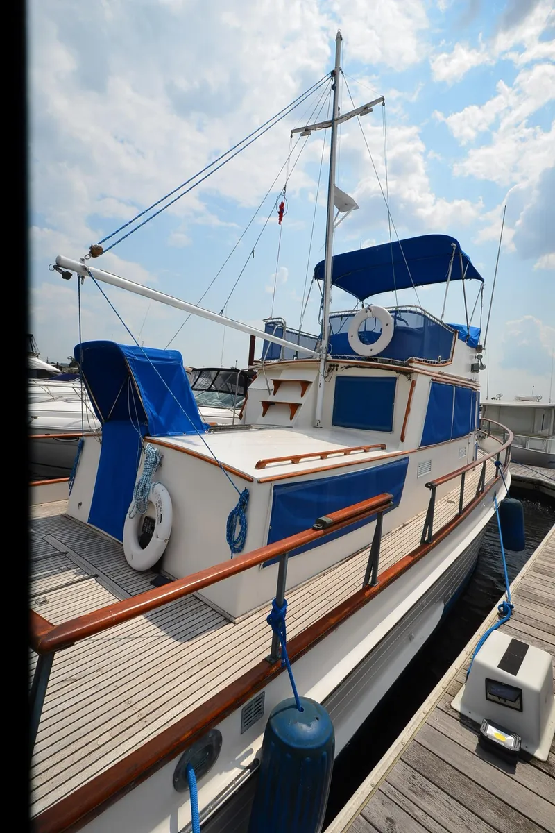 Slide: The Image of 1978 Grand Banks 36 Classic yacht docked, featuring blue accents and wooden railings. - 35