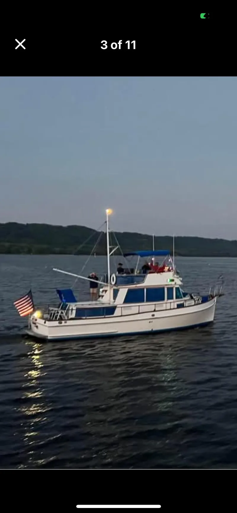 Slide: The Image of 1978 Grand Banks 36 Classic yacht cruising on a calm lake at dusk. - 37
