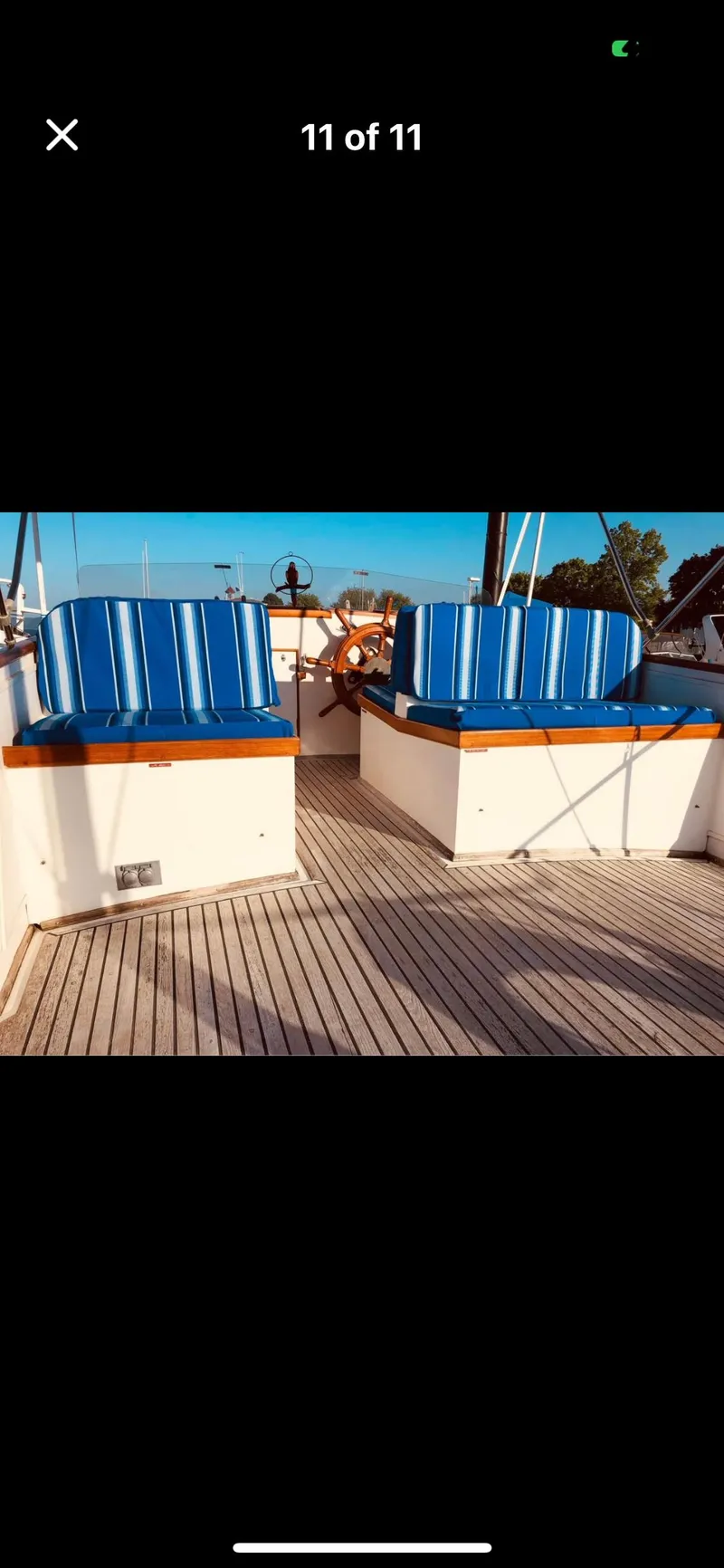 Slide: The Image of 1978 Grand Banks 36 Classic boat deck with blue-striped seating and wooden flooring. - 39